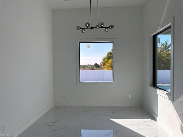Unfurnished dining area featuring healthy amount of natural light and marble finish flooring