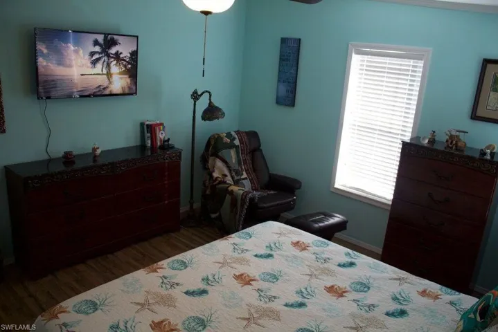Bedroom with wood finished floors and multiple windows