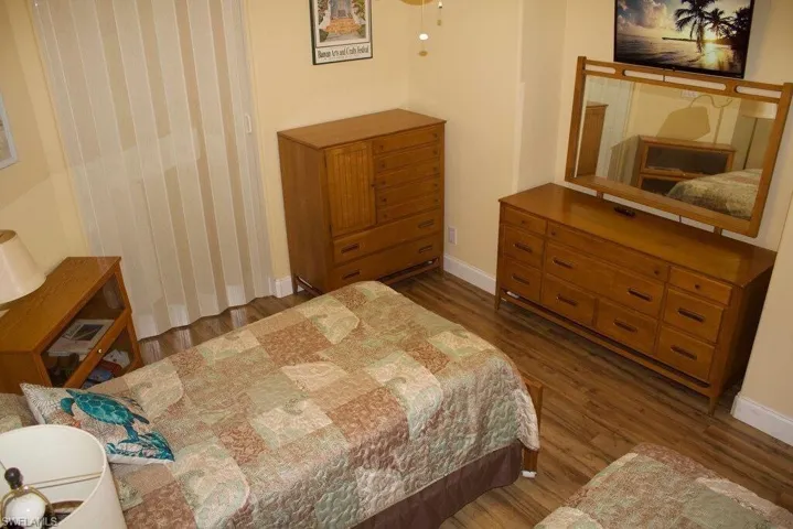 Bedroom with wood finished floors and baseboards