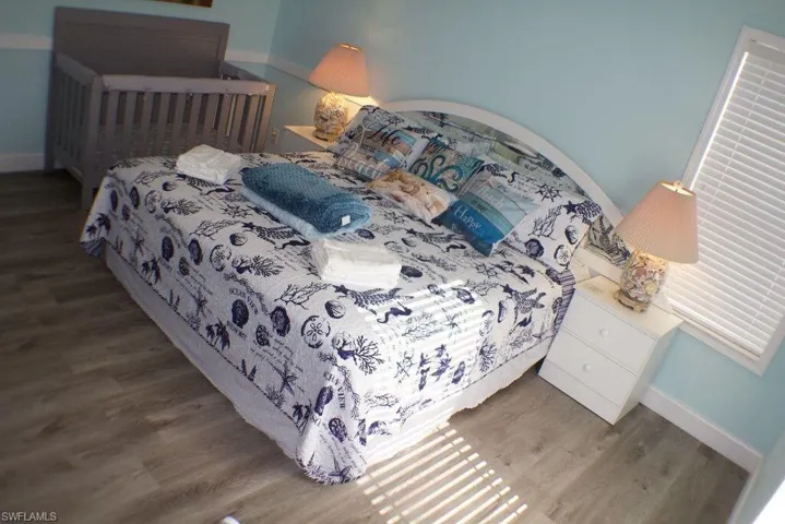 Bedroom with wood finished floors and baseboards