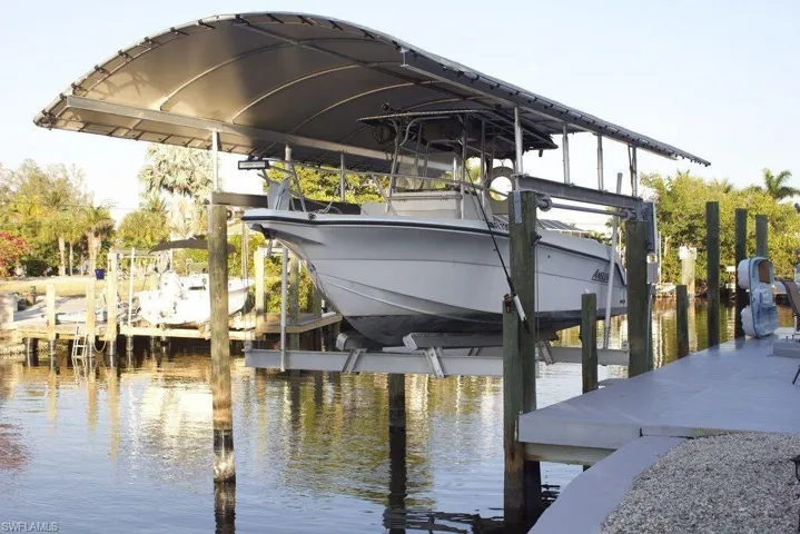 Dock featuring boat lift and a water view