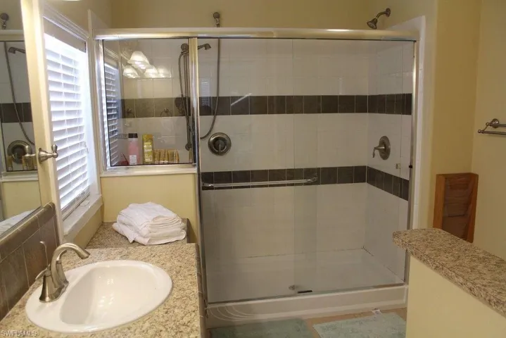 Full bath with a shower stall and vanity