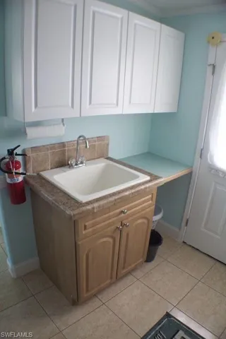 Kitchen featuring white cabinets, light tile patterned floors, and light countertops