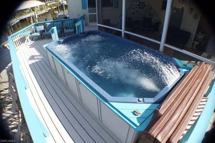 View of pool featuring a hot tub and a wooden deck