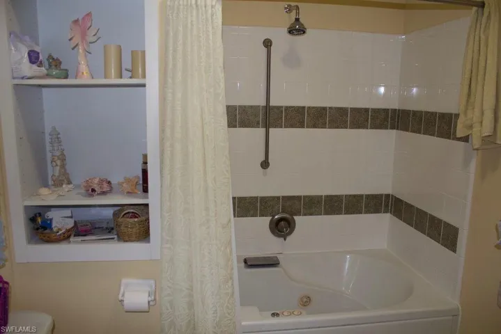 Bathroom featuring shower / bath combination with curtain and toilet