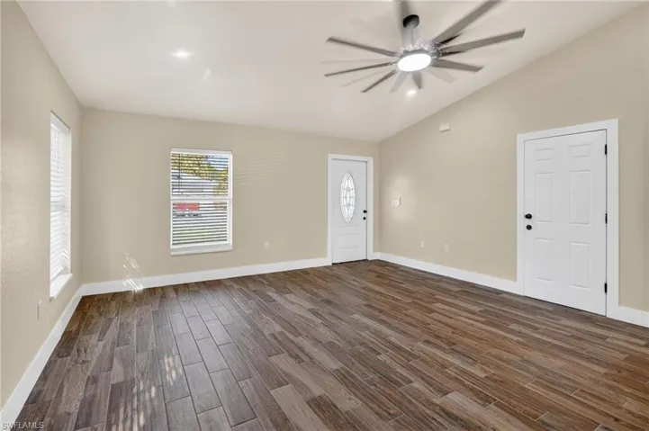 Entrance foyer featuring vaulted ceiling, wood finish floors, and ceiling fan