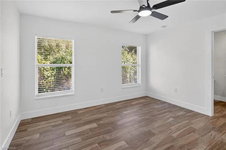 Unfurnished bedroom with ceiling fan and wood finished floors