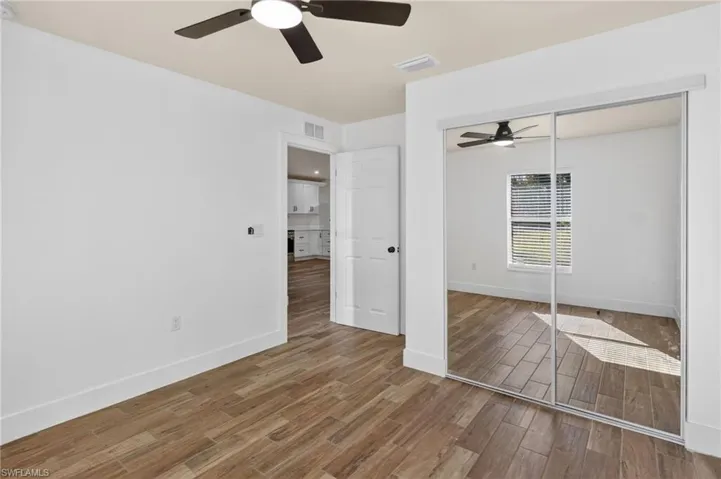 Unfurnished bedroom featuring wood finished floors, ceiling fan, and a closet