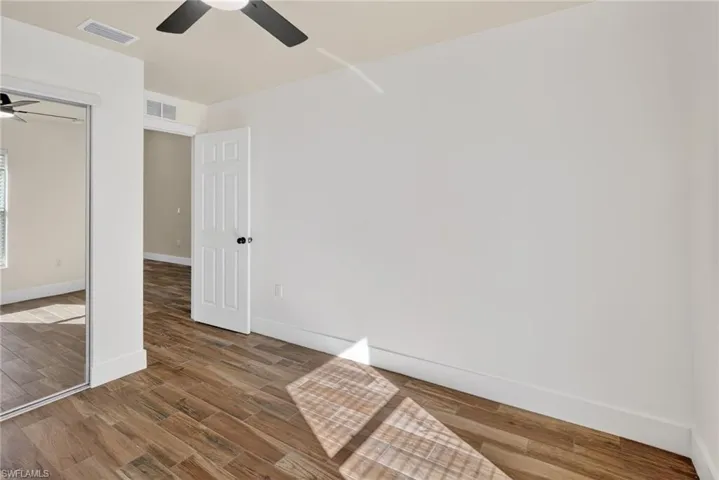 Unfurnished bedroom featuring dark wood finished floors, ceiling fan, and a closet