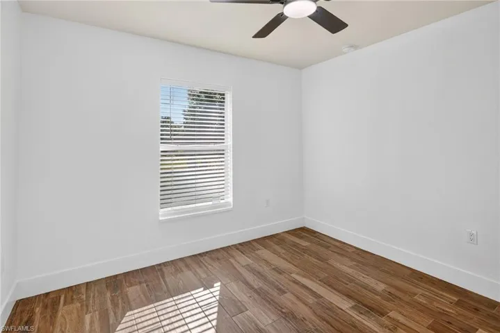 Unfurnished room with wood finished floors and a ceiling fan
