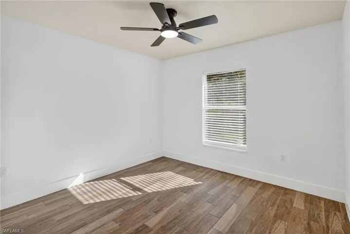 Empty room featuring wood finished floors and a ceiling fan