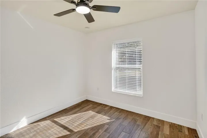 Unfurnished room with hardwood / wood-style flooring and a ceiling fan