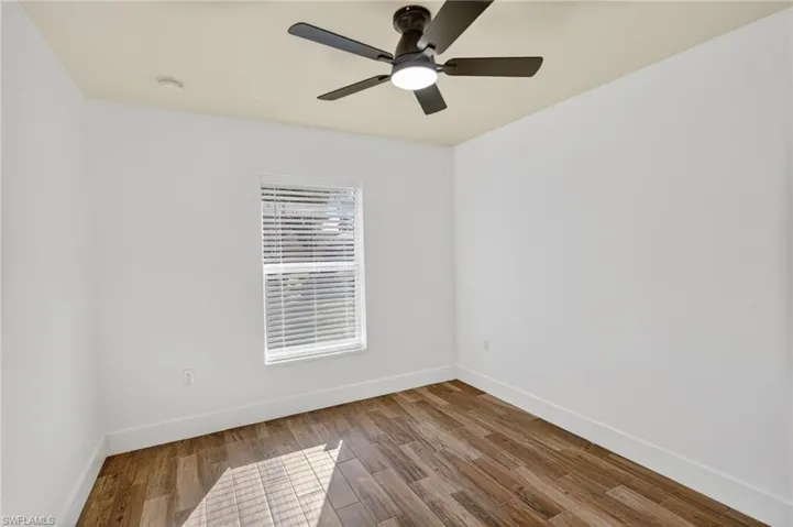 Spare room with wood finished floors and ceiling fan