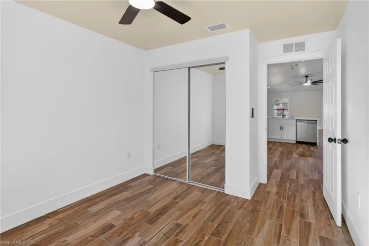 Unfurnished bedroom with dark wood finished floors, a closet, and a ceiling fan