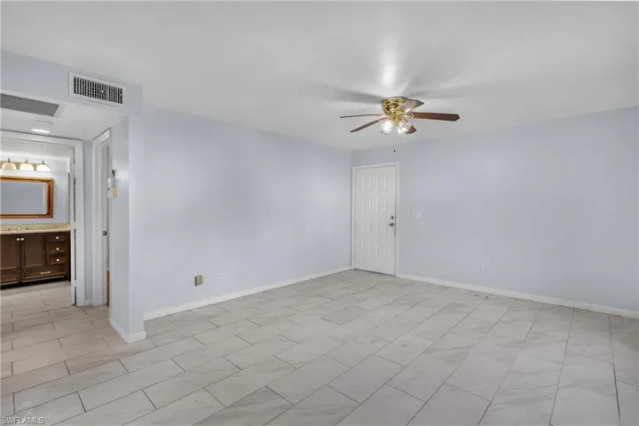 Unfurnished room with a ceiling fan and baseboards
