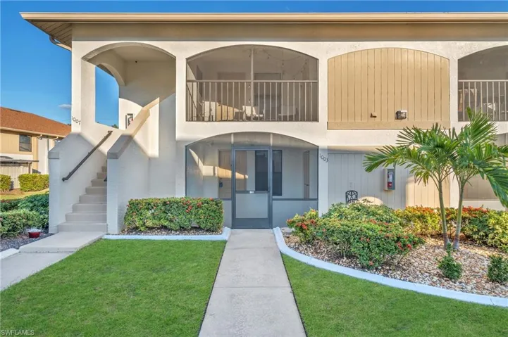Property entrance with a front yard and stucco siding