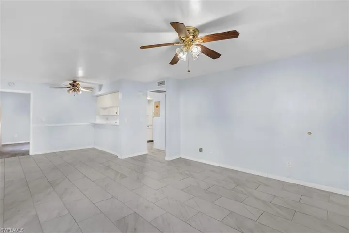 Empty room with ceiling fan and baseboards