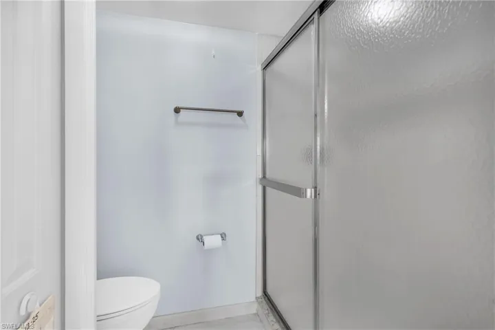 Bathroom with a shower stall and toilet