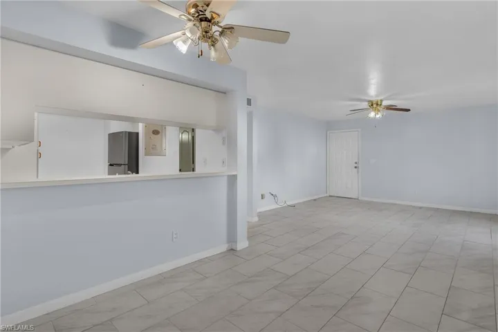 Spare room featuring a ceiling fan and baseboards