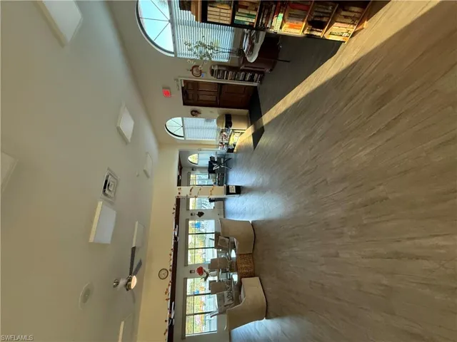 Living room with attic access, ceiling fan, and wood finished floors