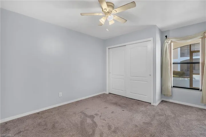 Unfurnished bedroom featuring a closet, carpet floors, and a ceiling fan