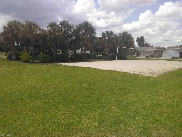 View of home's community featuring a bocce ball area and a yard