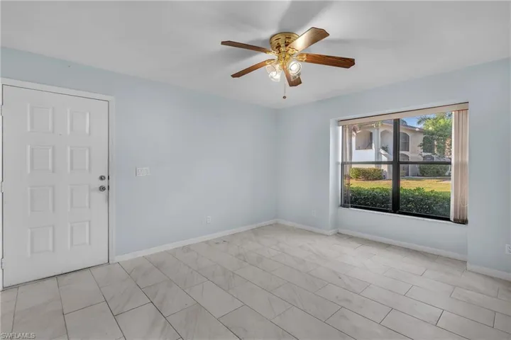Empty room featuring ceiling fan and baseboards