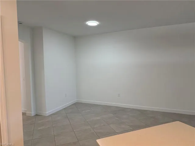 Interior space featuring neutral wall paint, large-format tile flooring, and recessed ceiling lighting