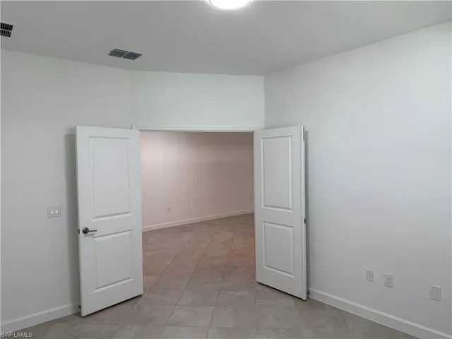 Interior space featuring tile flooring and double interior doors with a white finish