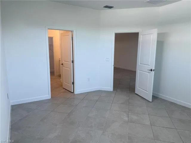 Room featuring large-format ceramic tile flooring, neutral walls, and two-panel interior doors
