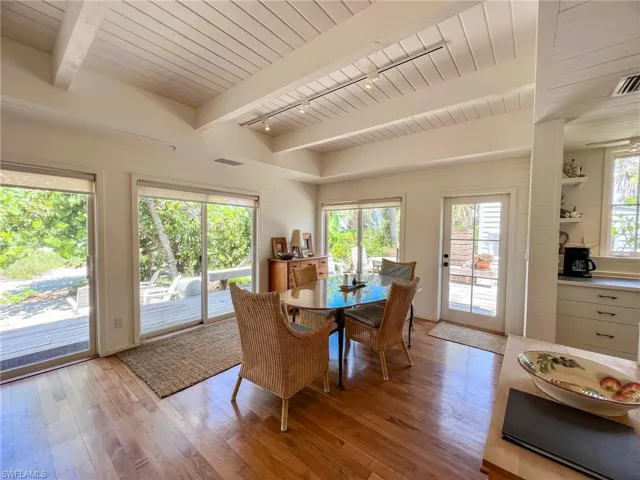Dining space with beamed ceiling, rail lighting, light wood-type flooring, and wooden ceiling
