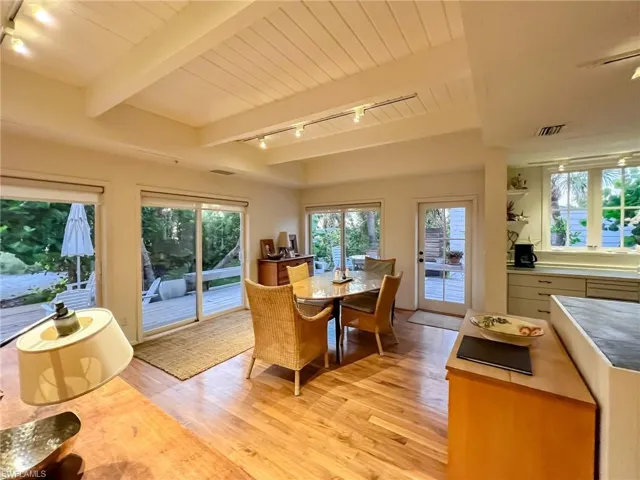 Dining space featuring beamed ceiling, rail lighting, and light wood-type flooring