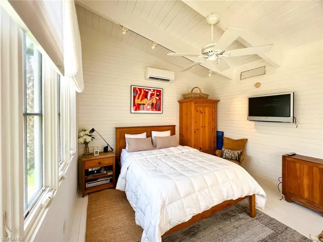 Bedroom with a wall unit AC, track lighting, ceiling fan, and wood ceiling