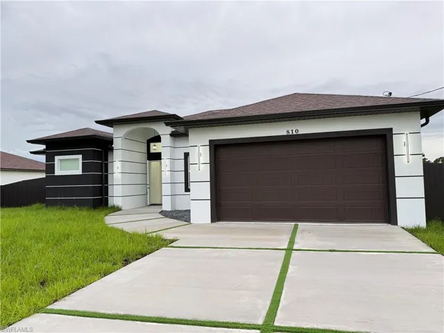 Prairie-style house featuring a shingled roof, concrete driveway, an attached garage, and stucco siding