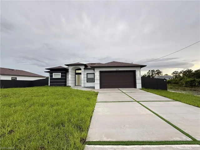 Prairie-style house featuring a garage, concrete driveway, and stucco siding