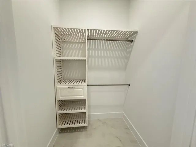Walk in closet featuring marble finish flooring
