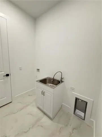 Washroom with light marble finish floors, electric dryer hookup, cabinet space, and washer hookup