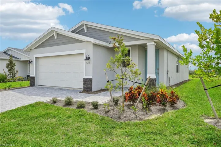 View of front of property featuring a garage and a front yard