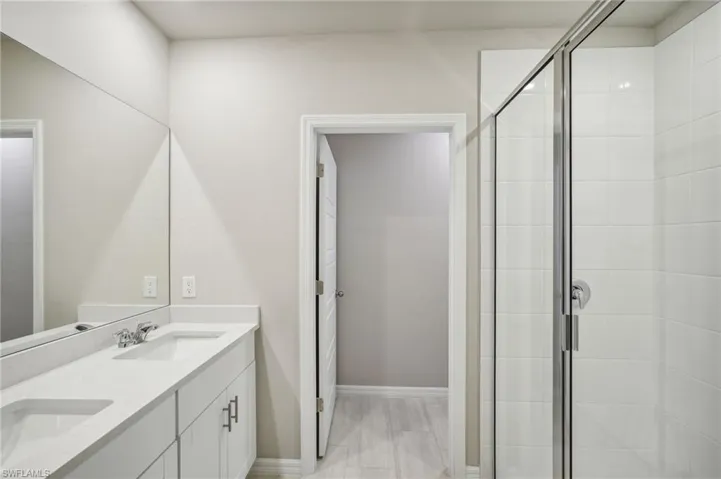 Bathroom with vanity and a shower with door