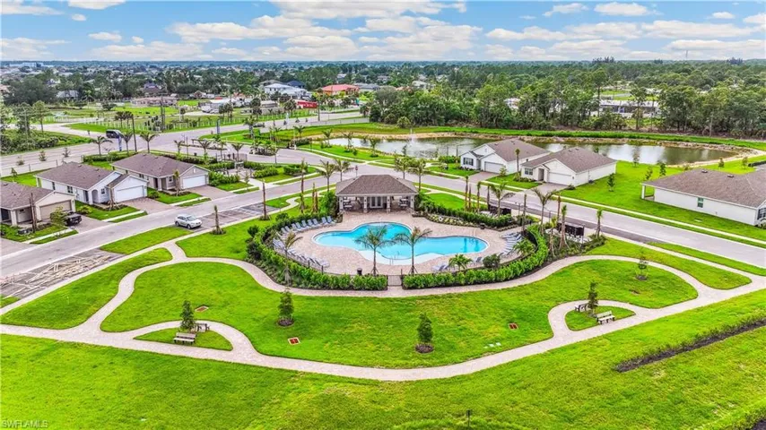 Aerial view of residential area with a nearby body of water and a pool area