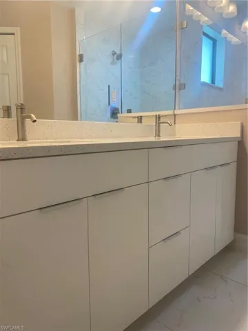 Bathroom featuring vanity and a shower with shower door