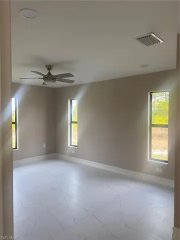 Empty room featuring plenty of natural light and ceiling fan