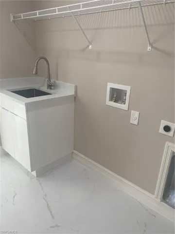 Laundry area with cabinets, electric dryer hookup, sink, and washer hookup
