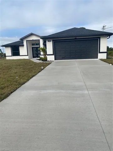 View of front of property featuring a garage and a front yard