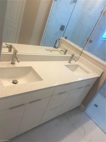 Bathroom featuring vanity and a tile shower