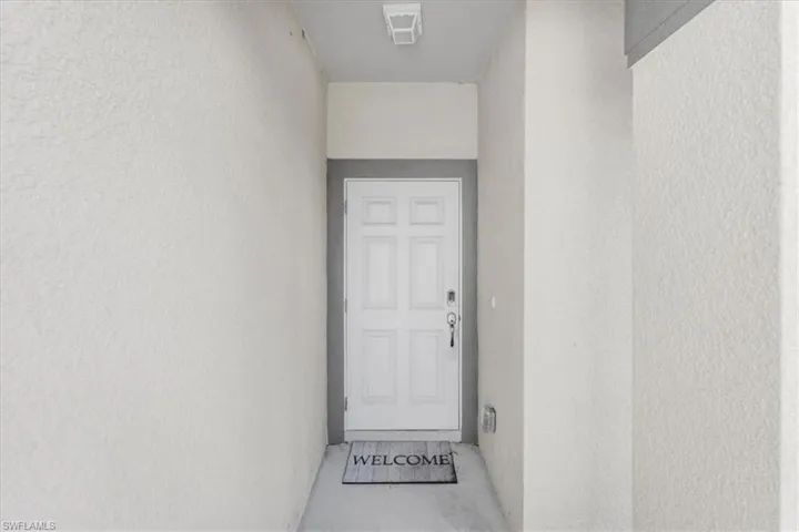 Doorway to property featuring stucco siding