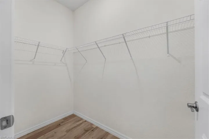 Walk in closet with light wood-type flooring