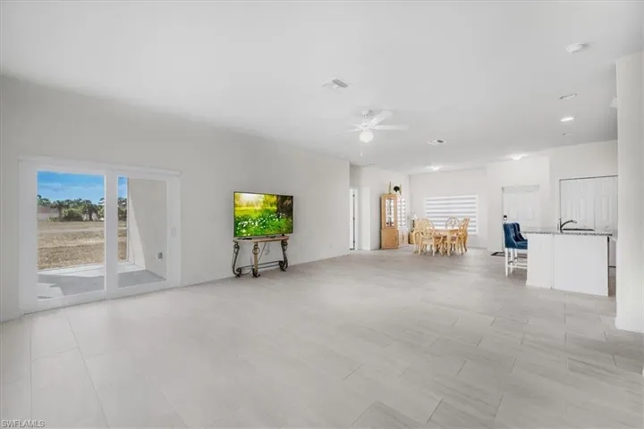 Unfurnished living room featuring ceiling fan and healthy amount of natural light