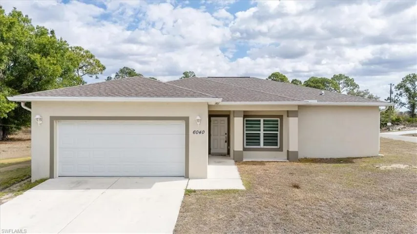Single story home with a garage, stucco siding, and concrete driveway