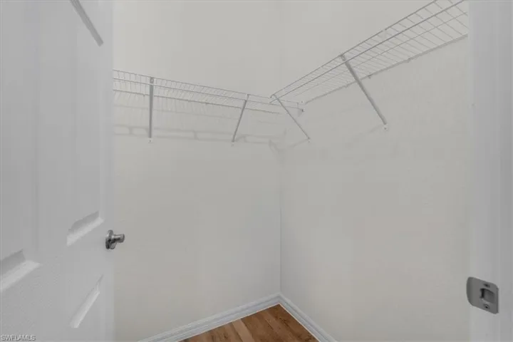 Walk in closet with light wood-style floors